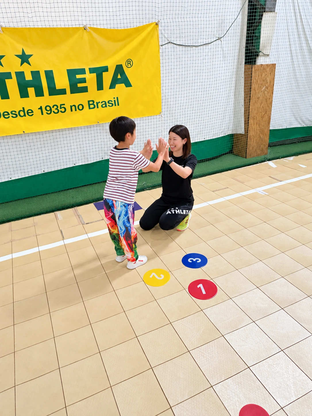 子どもとハイタッチを交わすスタッフ